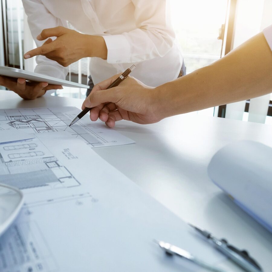 Planta técnica sendo analisada sobre a mesa